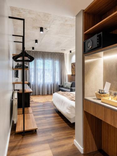 a bedroom with a bed and a living room at Refúgio Boutique com Piscina Aquecida in Canela