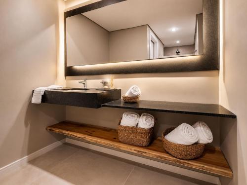 a bathroom with a sink and a mirror at Refúgio Boutique com Piscina Aquecida in Canela