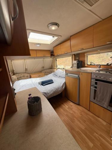 a small room with a bed and a kitchen at Little hideaway in Costa da Caparica