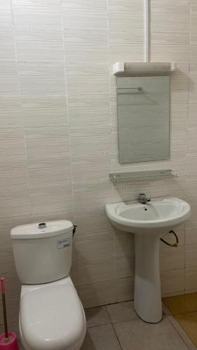 a bathroom with a toilet and a sink at New ACROPOLE APPART in Komé