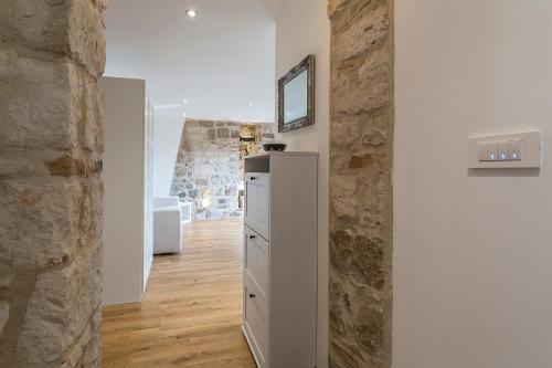 Zimmer mit einem Kühlschrank und einer Steinmauer in der Unterkunft Apartment Lara in Split