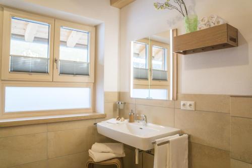 een badkamer met een wastafel en een spiegel bij Ferienwohnung In den Bergen in Oberammergau