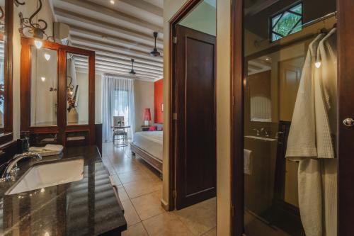 a bathroom with a bed and a sink and a mirror at Casa Zafiro Hotel - Adults Only, Mérida in Mérida