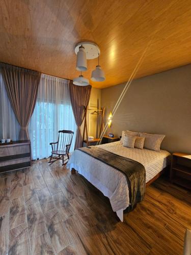 a bedroom with a bed and a chair in a room at Finca La Concepción in Marcala