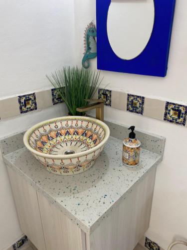 a bathroom with a sink on a counter with a mirror at Casa Jardin Rosarito in Rosarito