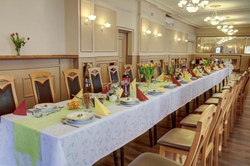 długi stół w pokoju ze stołami i krzesłami w obiekcie Karet Obiekt Hotelowy w mieście Skoczów