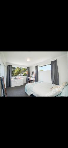 a bedroom with a bed and a large window at Otatara Bush Haven in Otatara