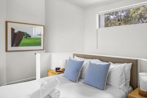 a bedroom with a bed with blue and white pillows at The View in Lorne