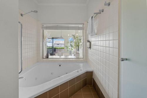 a white bath tub in a bathroom with a window at The View in Lorne