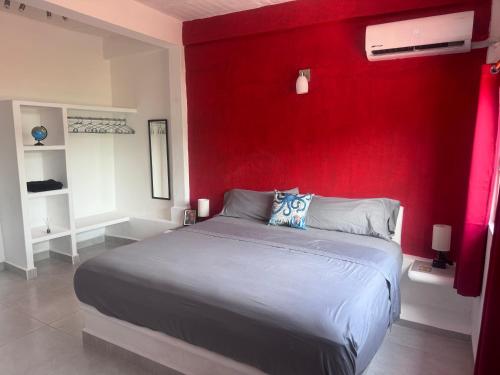 a bedroom with a red wall and a bed at Casa Dreamy in Zihuatanejo