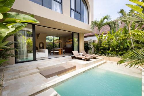 a house with a swimming pool in front of a house at SISI Wellness Villas in Bingin Beach