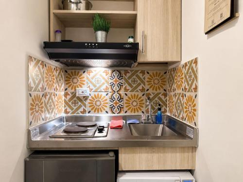 a small kitchen with a sink and a stove at La Gruta Coliving in Medellín