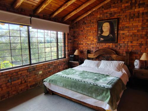a bedroom with a bed in a brick wall at La Toscana, Chalet Campestre in Guasca