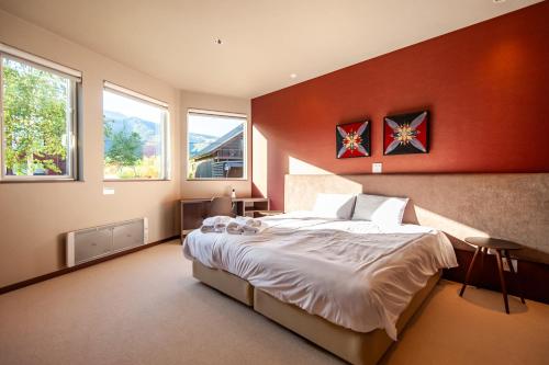 a bedroom with a large bed and two windows at The Orchards Niseko in Kutchan