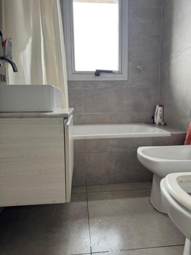a bathroom with a tub and a sink and a toilet at Luxury in Villa Carlos Paz