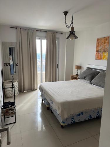 a bedroom with a bed and a large window at Luxury in Villa Carlos Paz
