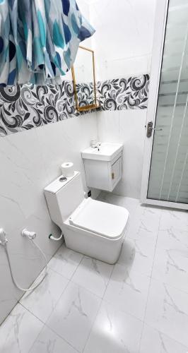 a white bathroom with a toilet and a shower at Amazonite Maldives in Thulusdhoo