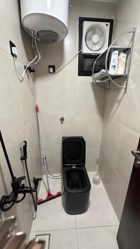 a small bathroom with a black toilet in a room at غرفتين وصالة شقق ديما الفندقية in Abha