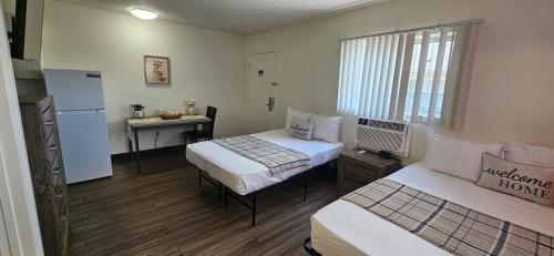 a room with two beds and a refrigerator and a table at Siegel Select Orange Park in Orange Park