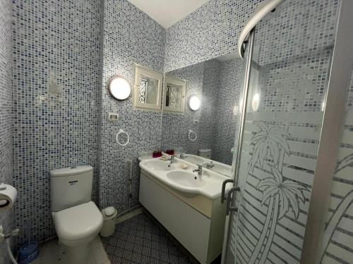 a bathroom with a toilet and a sink and a shower at Cosy 1BD Pool, Beach, Large Terrace in Hammam Sousse