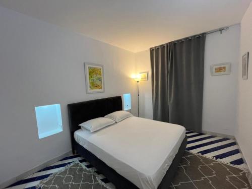 a bedroom with a white bed in a room at Cosy 1BD Pool, Beach, Large Terrace in Hammam Sousse