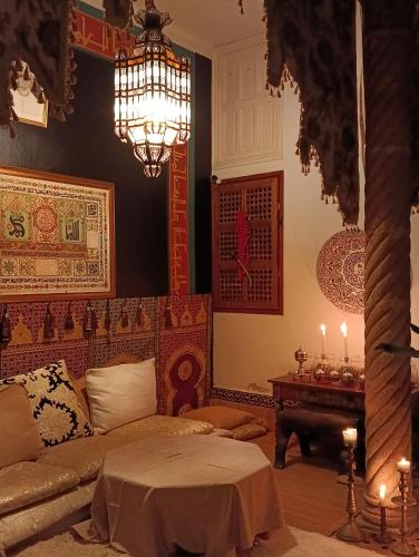 a living room with a couch and a chandelier at Riad Dar Badiaa in Salé