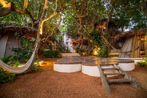 a hammock in the middle of a yard with trees at Treehouse Kitecamp Jericoacoara in Jericoacoara