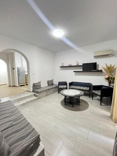 a living room with a table and a couch at Marina Escape, 2BD, Pool and Beach in Hammam Sousse