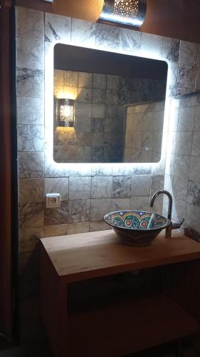 a bathroom counter with a sink and a mirror at Riad Dar Badiaa in Salé