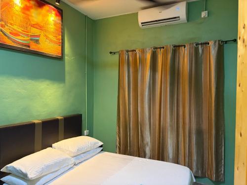 a bedroom with a bed and a shower curtain at Sri impiana in Pantai Cenang