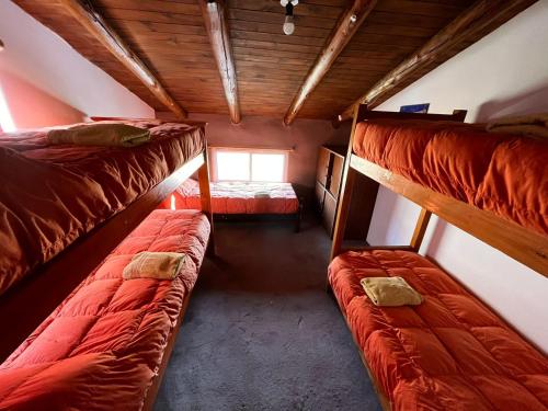 a room with two bunk beds and a window at Refugio Pehuenche in Los Molles