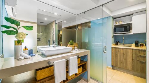 a bathroom with a sink and a glass shower at Gorgeous 1BR Condo with Pools & Sea Views in Puerto Vallarta