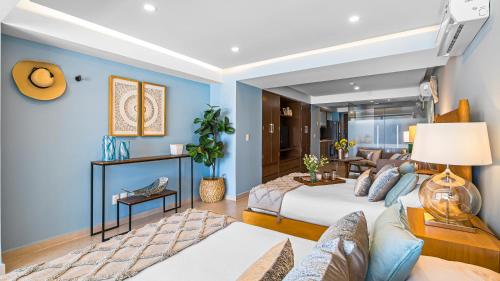 a hotel room with two beds and a couch at Gorgeous 1BR Condo with Pools & Sea Views in Puerto Vallarta