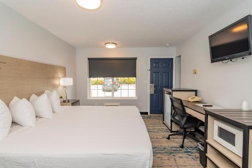 a hotel room with a bed and a desk at Sweet Breeze Inn Grants Pass in Grants Pass
