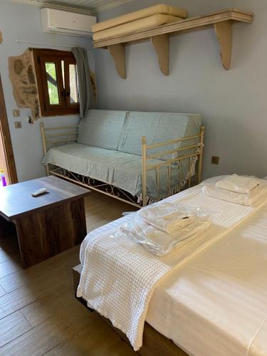 a bedroom with two twin beds and a table at Περιβόλι του Οδυσσέα in Volissos