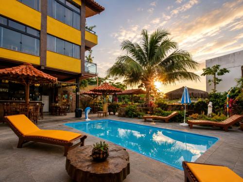 a resort pool with chairs and a hotel at Pousada Mirante Pôr do Sol in Maricá