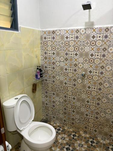 a bathroom with a toilet and a shower at Sri impiana in Pantai Cenang