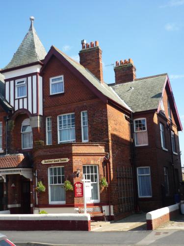 a large red brick house with a roof at Boulmer Guest House in Whitby