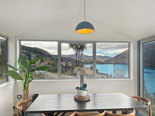 a dining room with a table and a large window at Epic Views and Deck | Spacious Queenstown Home in Queenstown