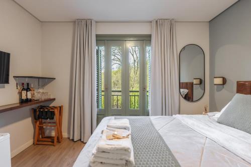 a bedroom with a bed with towels on it at Pousada Calza - Vale dos Vinhedos - Bento Gonçalves in Bento Gonçalves