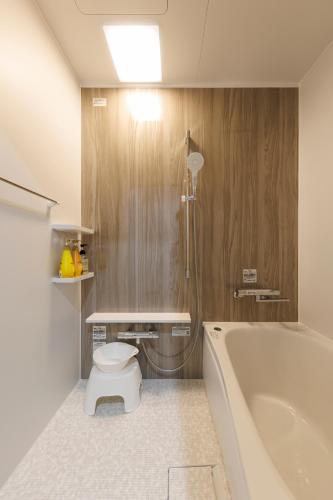 a bathroom with a toilet and a bath tub at あかねや in Marugame