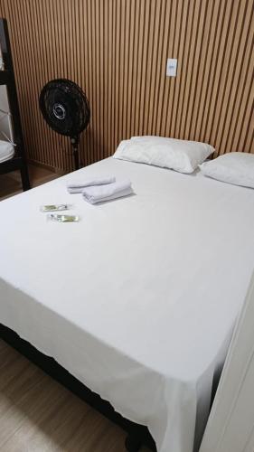 a bed with white sheets and towels on it at Lar Luar do Sertão in Aracaju