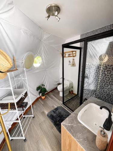 a bathroom with a sink and a toilet in a tent at Romantic Dome & French Cuisine in Jantetelco