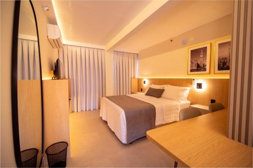 a hotel room with a bed and a table at Oklahoma Inn in Foz do Iguaçu