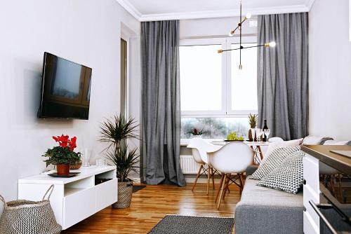 uma sala de estar com um sofá e uma mesa em Apartamenty Grażyna Słodowiec em Varsóvia
