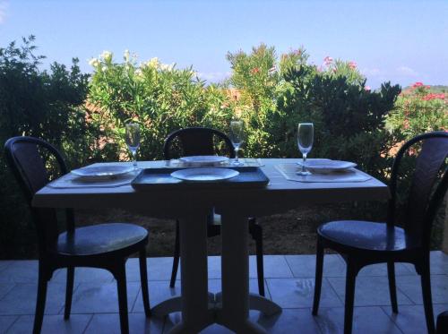 CasaglioneにあるPanoramic Seaview studio Tiucciaのテーブル(椅子付)、パティオ(ワイングラス付)