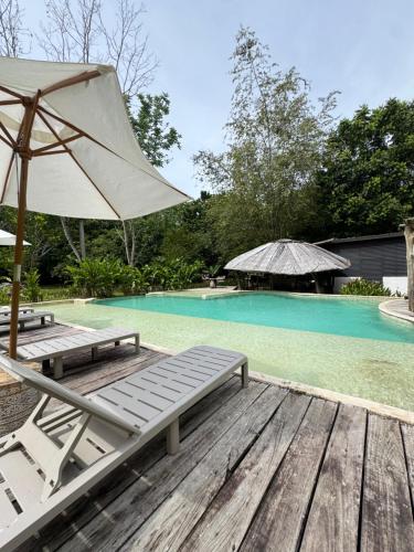 a pool with two lounge chairs and an umbrella at Akasha suites in Doradal