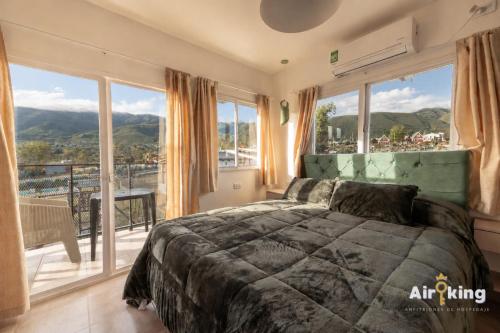 a bedroom with a bed and a large window at Suites Amplias y Comfortables - Con Balcon, Parquizado, Asador y Pileta in Tafí del Valle