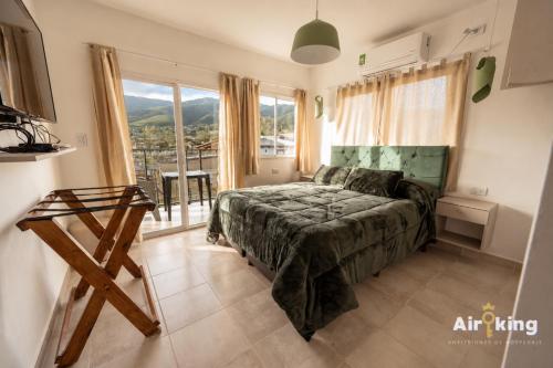 a bedroom with a bed and a large window at Suites Amplias y Comfortables - Con Balcon, Parquizado, Asador y Pileta in Tafí del Valle