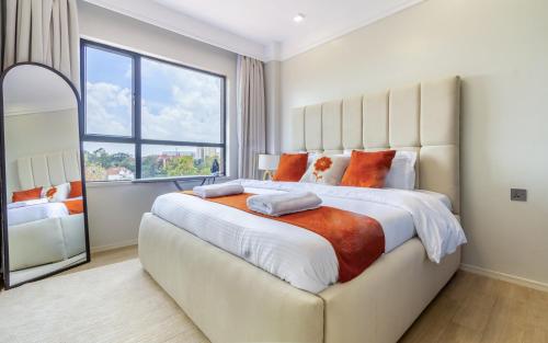 a large bed in a bedroom with a large window at Everlett Lavington Homes in Nairobi